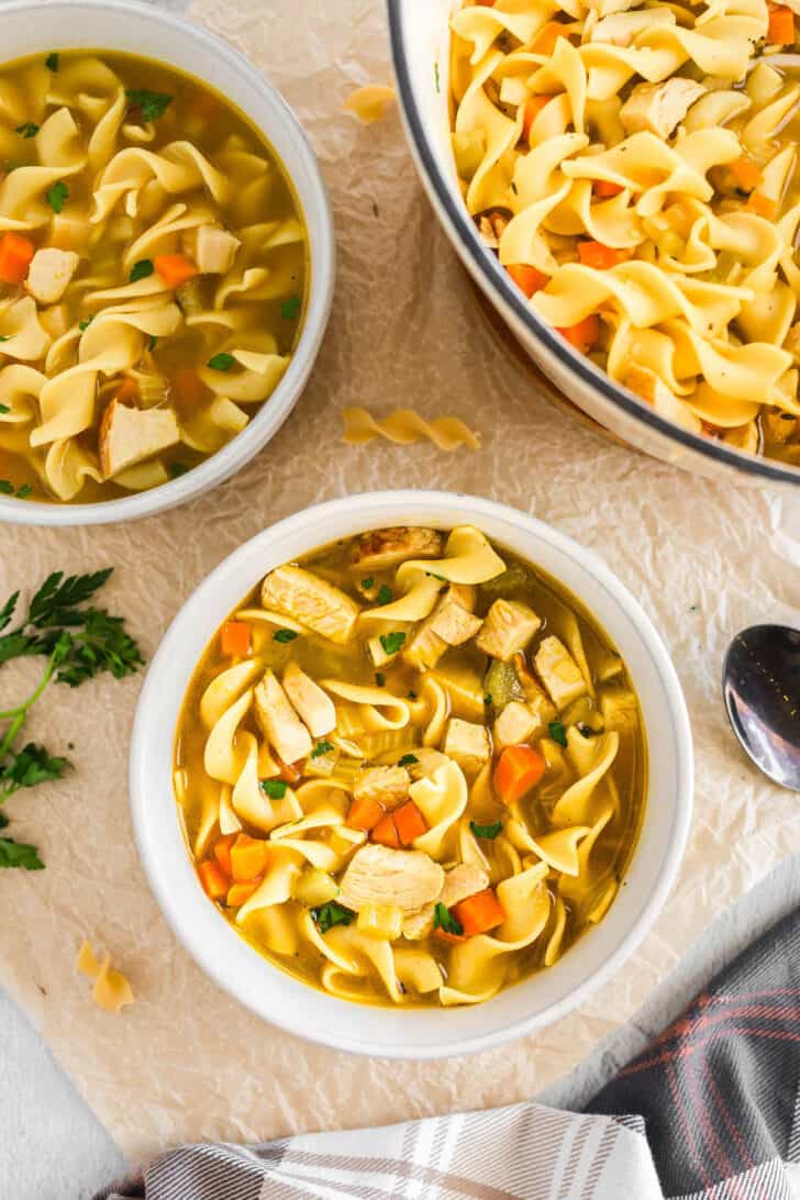 Two white bowls with servings of a turkey soup recipe in them.