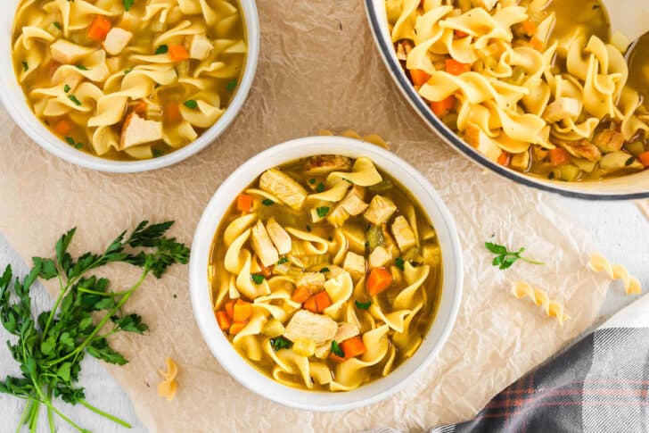 Two white bowls filled with the best turkey soup.