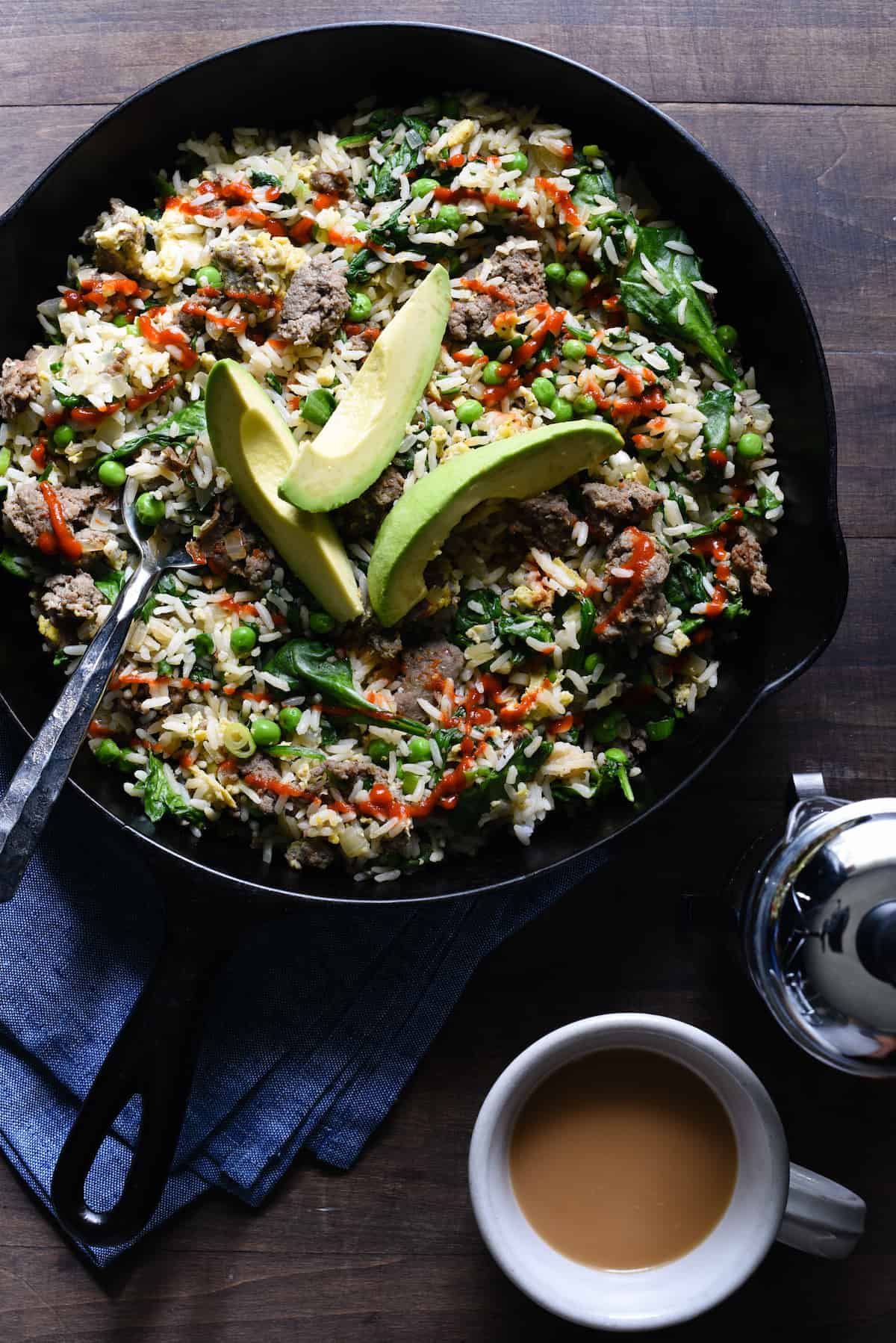 Break out a big cast iron skillet and feed a crowd with this Breakfast Fried Rice. Full of lean turkey sausage, eggs and lots of veggies, this will keep the crew fueled all morning. | foxeslovelemons.com Cast iron skilled filled with breakfast fried rice, topped with avocado slices.