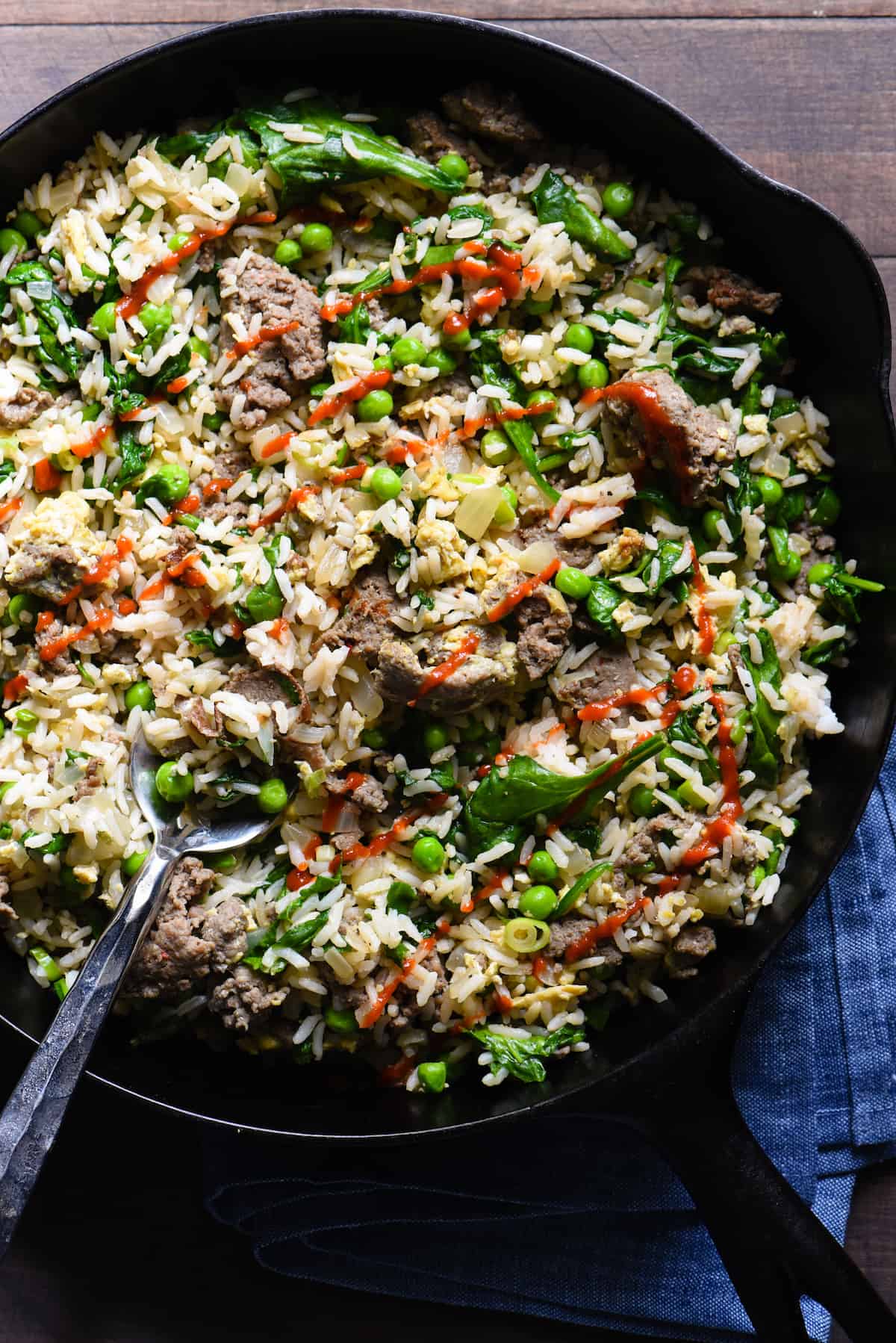 Break out a big cast iron skillet and feed a crowd with this Breakfast Fried Rice. Full of lean turkey sausage, eggs and lots of veggies, this will keep the crew fueled all morning. | foxeslovelemons.com Cast iron skilled filled with breakfast rice, topped with avocado slices.