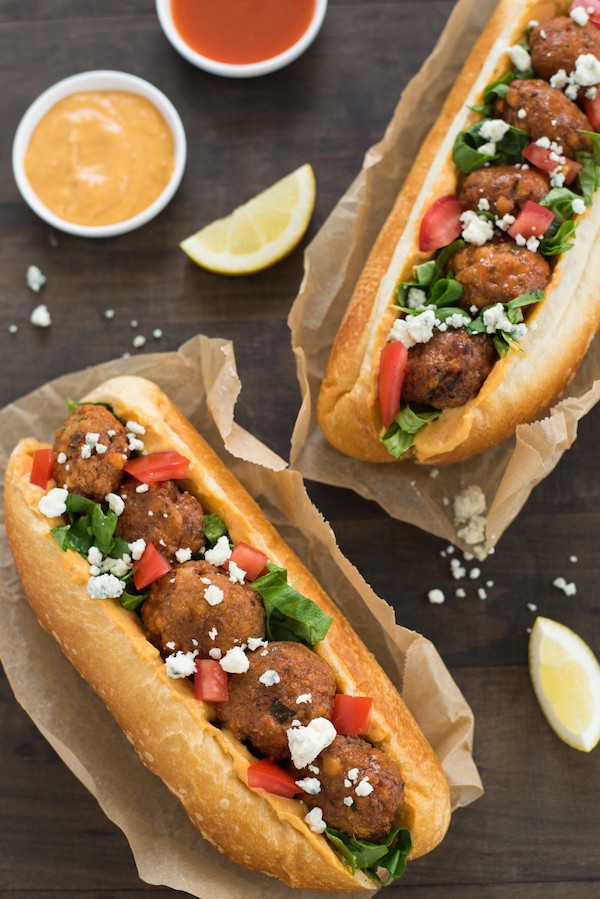 Buffalo Falafel Subs - Fried chickepea fritters are tossed in buffalo sauce then piled into subs with buffalo-flavored hummus, lettuce, tomato and blue cheese! | foxeslovelemons.com