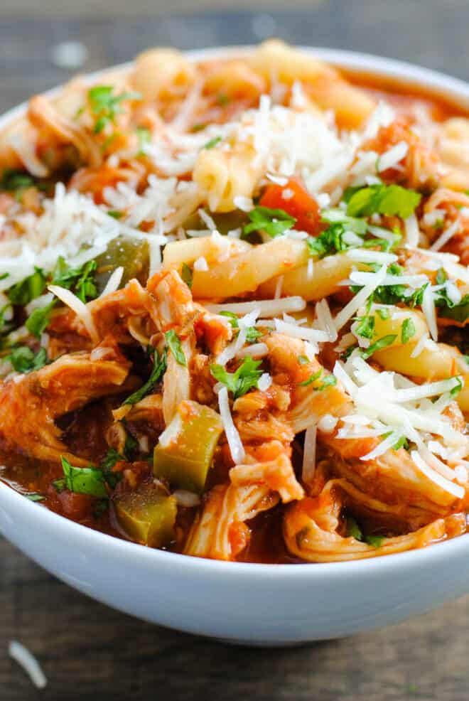 Closeup on slow cooker chicken parmesan soup sprinkled with cheese.