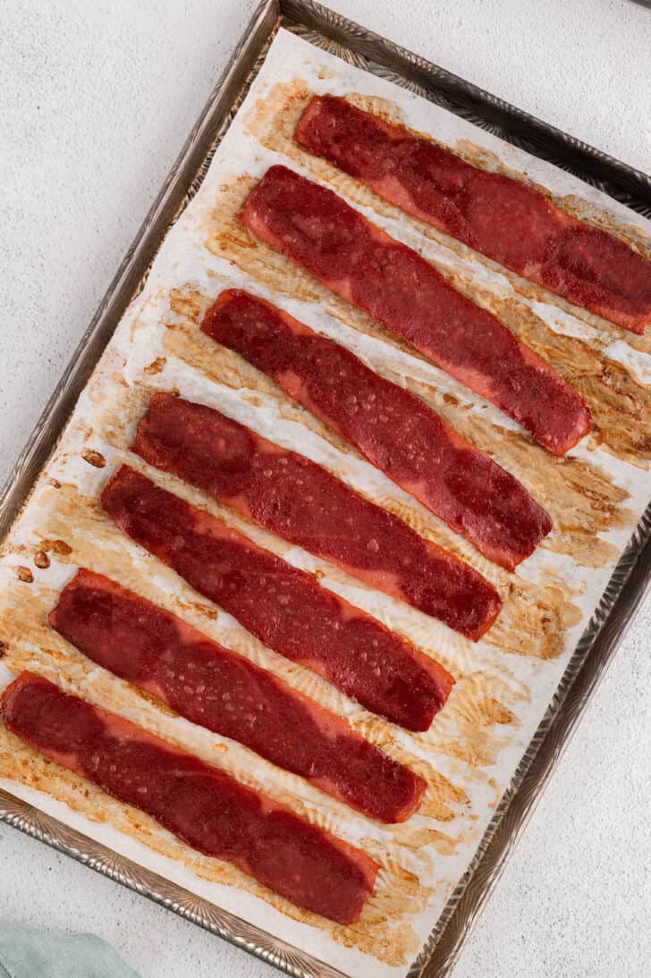 Cooked rashers on a rimmed baking pan.