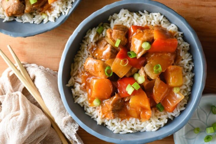 Slate blue bowl filled with rice and pressure cooked Asian chicken dish.