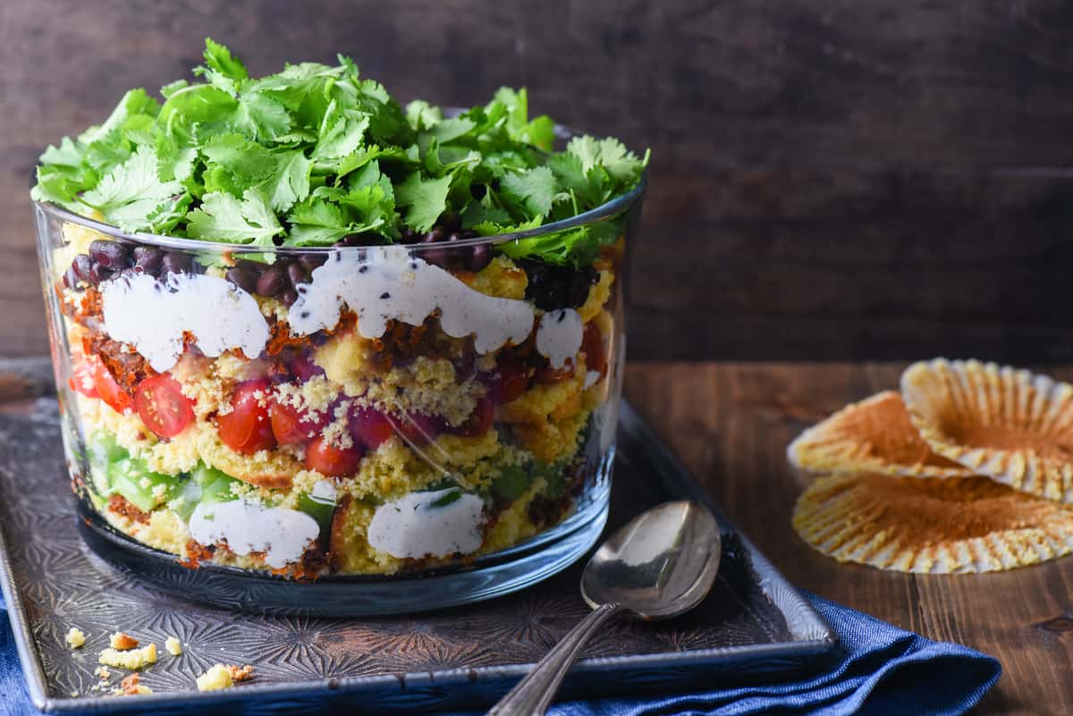 Having a backyard barbecue or going to a potluck? This Layered Southwestern Cornbread Salad can be made in advance and served cold. With the layers of colors and flavors, it's certain to stand out on the buffet table. | foxeslovelemons.com