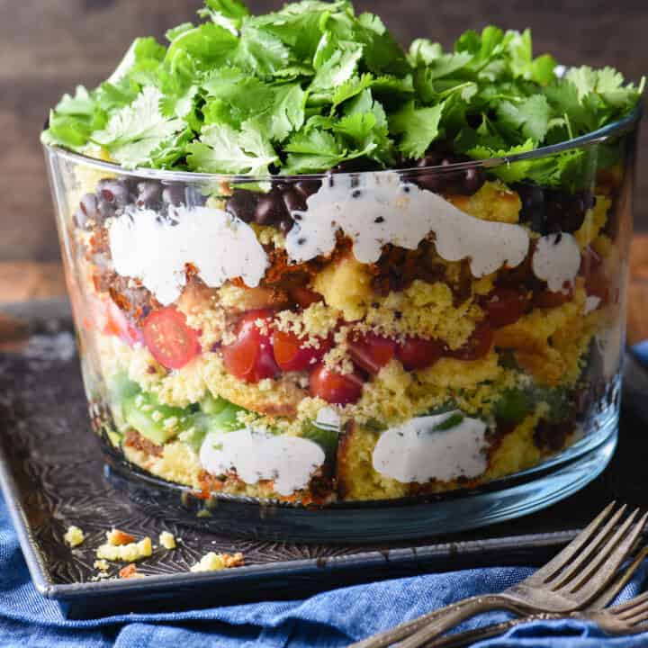 Having a backyard barbecue or going to a potluck? This Layered Southwestern Cornbread Salad can be made in advance and served cold. With the layers of colors and flavors, it's certain to stand out on the buffet table. | foxeslovelemons.com