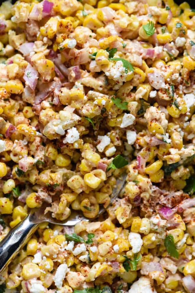 Closeup on sweetcorn and feta cheese salad dish.