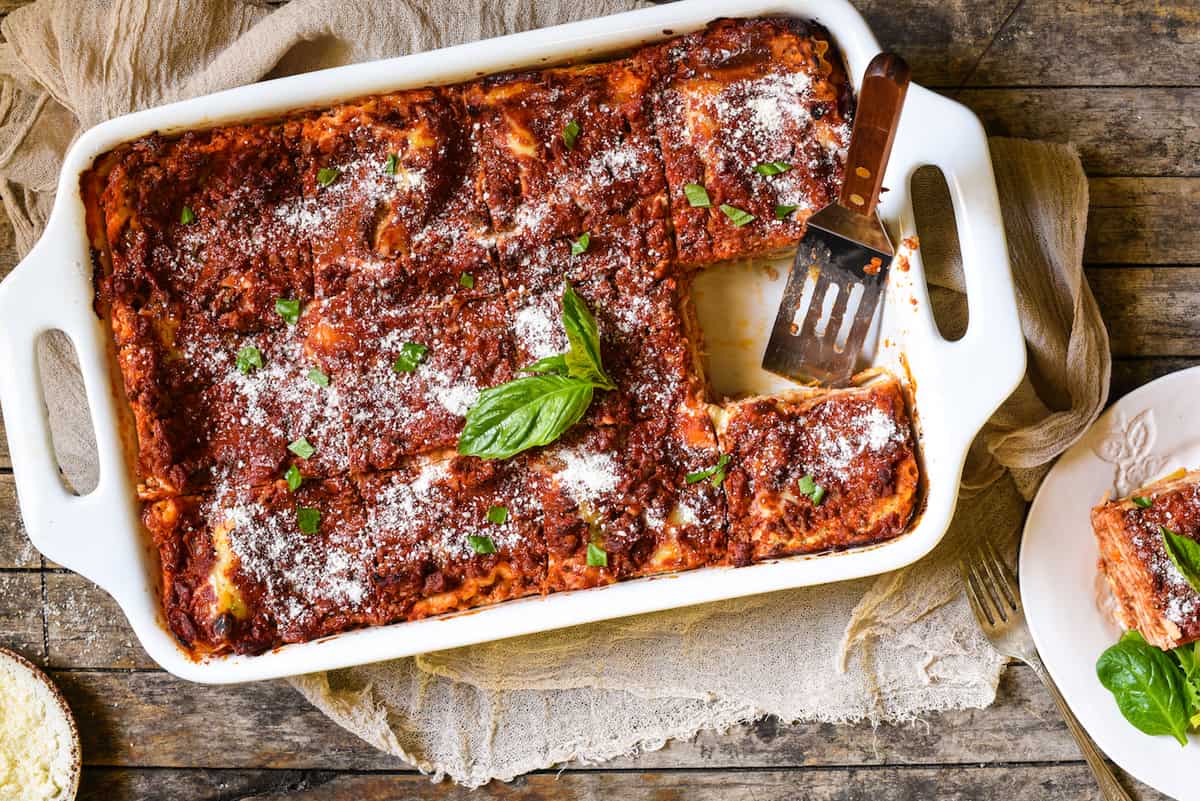 Lasagna with Cottage Cheese - A classic Midwestern noodle casserole. Layers of rich meat sauce, pasta, creamy filling and cheese will have the whole family coming back for seconds! | foxeslovelemons.com Overhead photo of a large white casserole dish filled with a Italian pasta casserole.