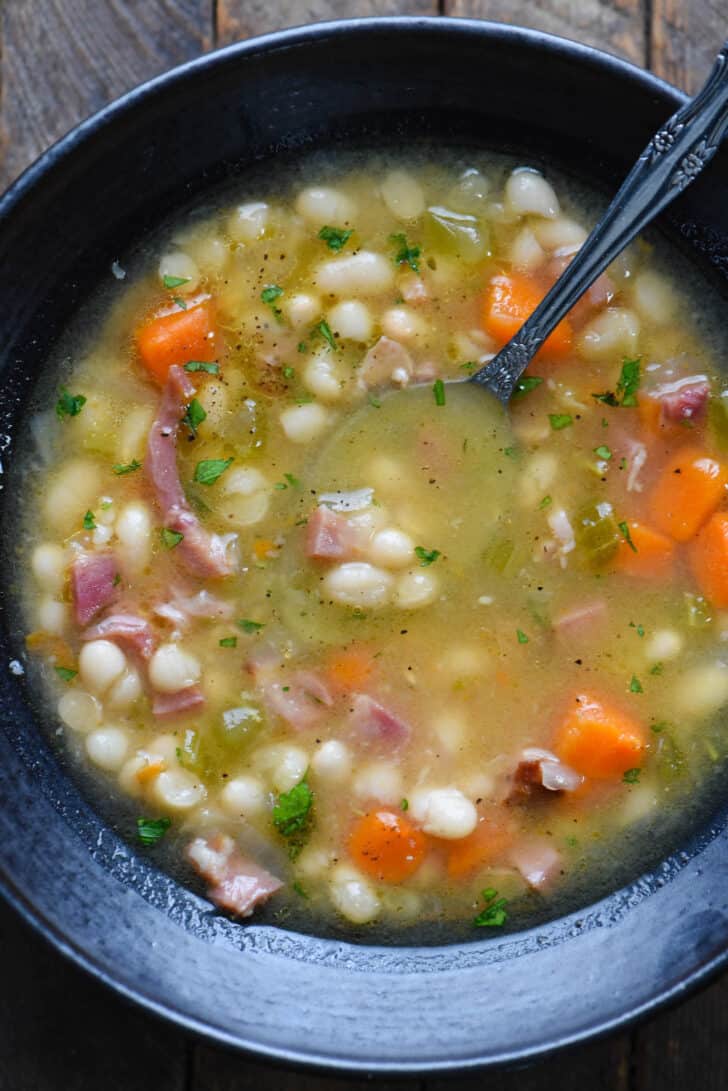 Closeup on a black bowl filled with rustic vegetable and pork stew.