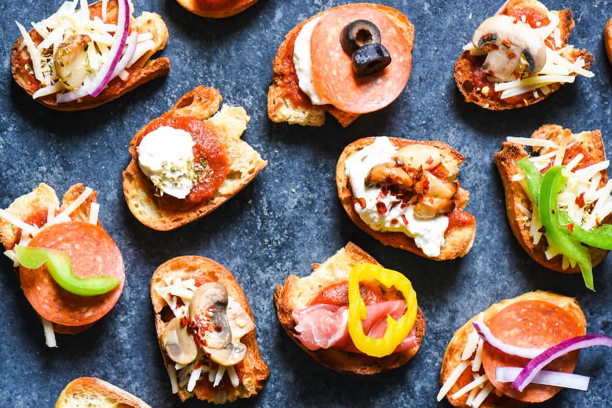 Pizza Crostini Bar - Put out some toasted bread and a big spread of pizza toppings, and let everybody make their own appetizer. So fun for parties! | foxeslovelemons.com Toasted baguette slices topped with tomato sauce, cheese and a variety of meat and vegetable toppings.