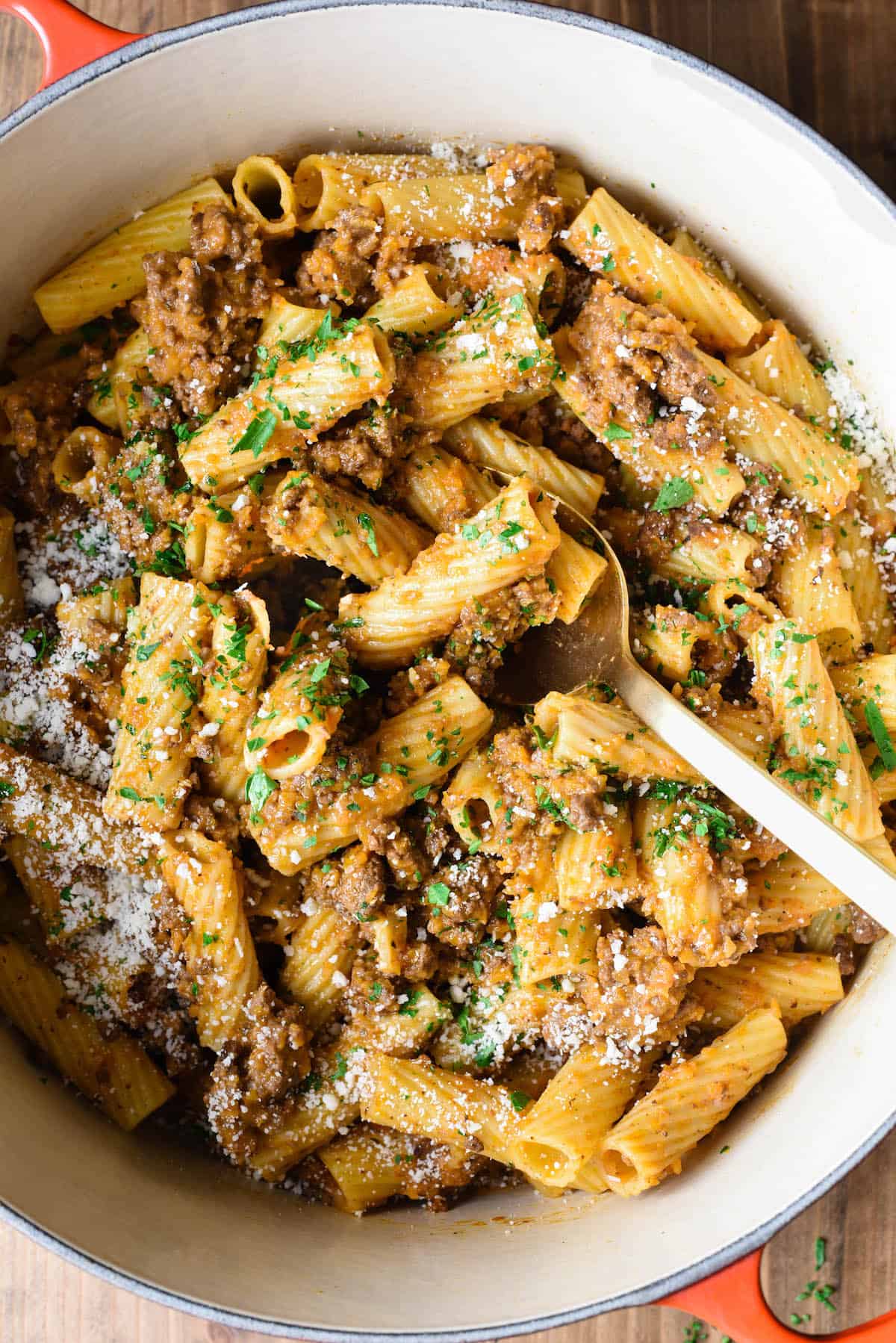 A bowl of this Rigatoni Bolognese will hit the spot whenever you have a pasta craving. This easy but elegant meat sauce recipe will give you a restaurant quality dish right at home. | foxeslovelemons.com Overhead photo of Dutch oven filled with rigatoni bolognese.