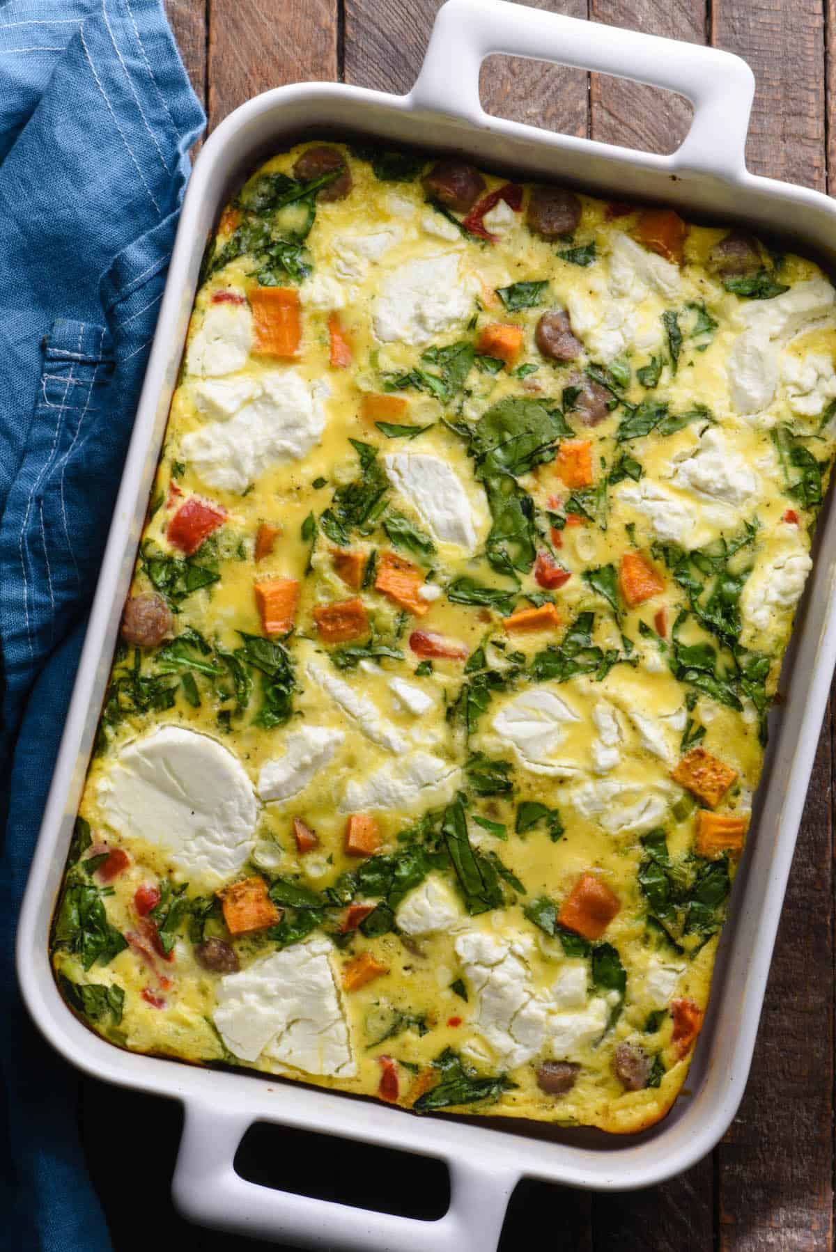This Sweet Potato Breakfast Casserole is a great meal prep recipe. Easy to reheat for breakfast and lunch throughout the week! | foxeslovelemons.com Egg bake made with sweet potatoes, sausage, spinach and goat cheese, in rectangular white baking dish.