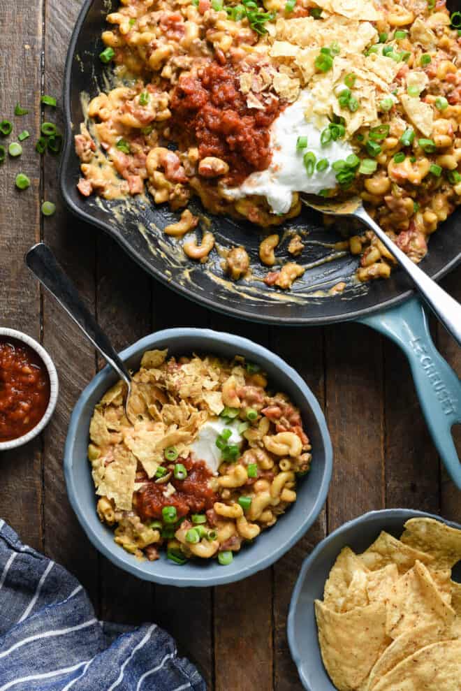 Large skillet of Mexican pasta dish, with serving in smaller bowl nearby. 