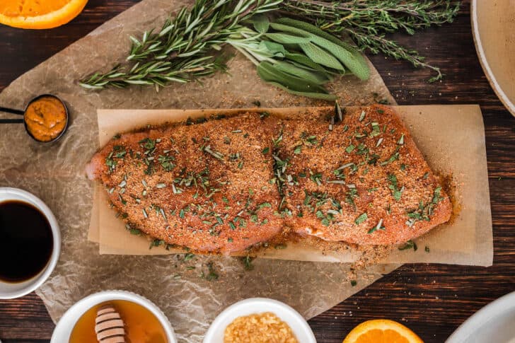 A turkey breast tenderloin recipe being prepared for the oven with a spice and herb rub.